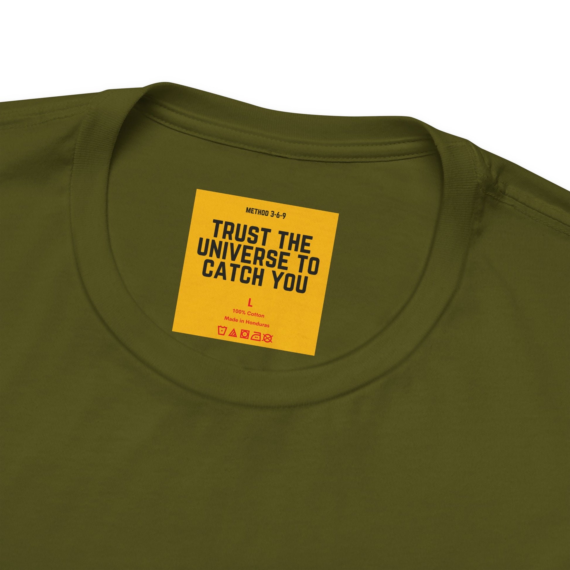 Green t-shirt with a yellow label featuring text on a white background- Trust Teh Universe To Catch You