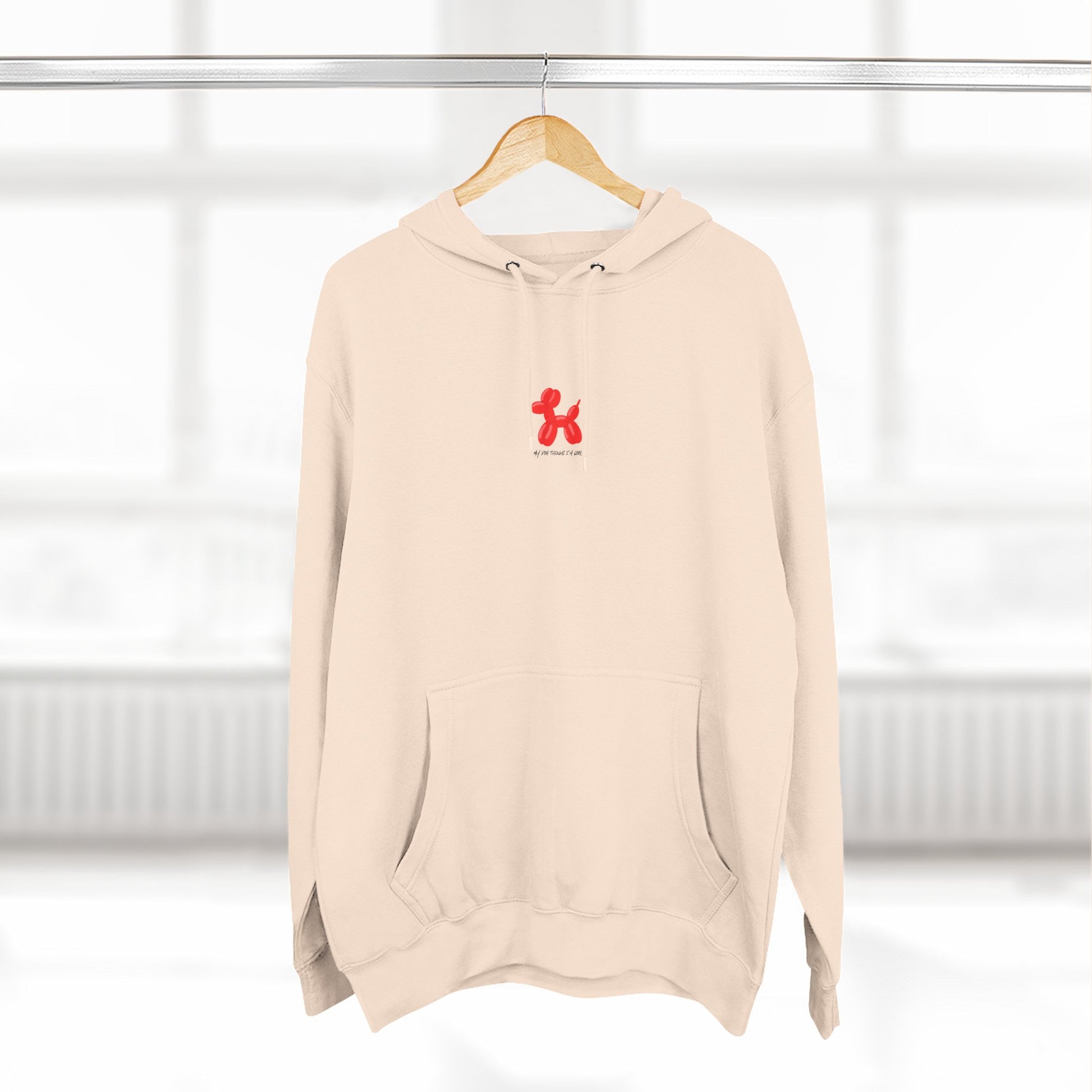 sandshell pullover hoodie with my dog thinks i'm cool text and red balloon dog graphic on hanger
