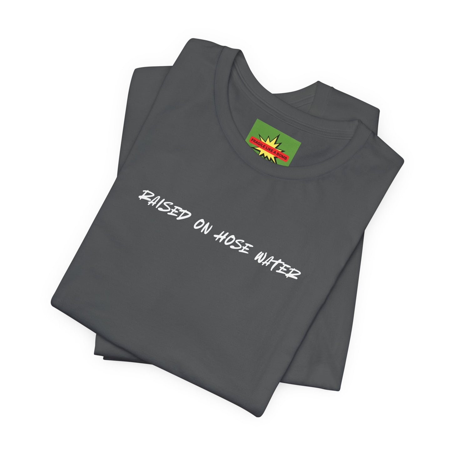 Close-up of RAISED ON HOSE WATER fragile like a bomb text on asphalt cotton tee