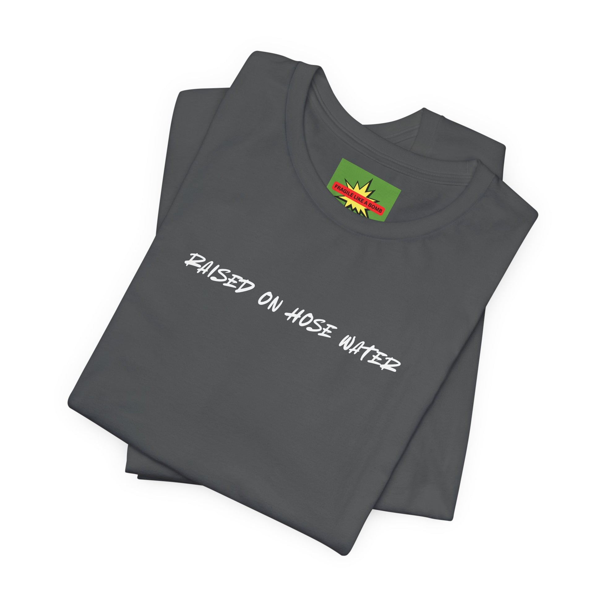 Close-up of RAISED ON HOSE WATER fragile like a bomb text on asphalt cotton tee