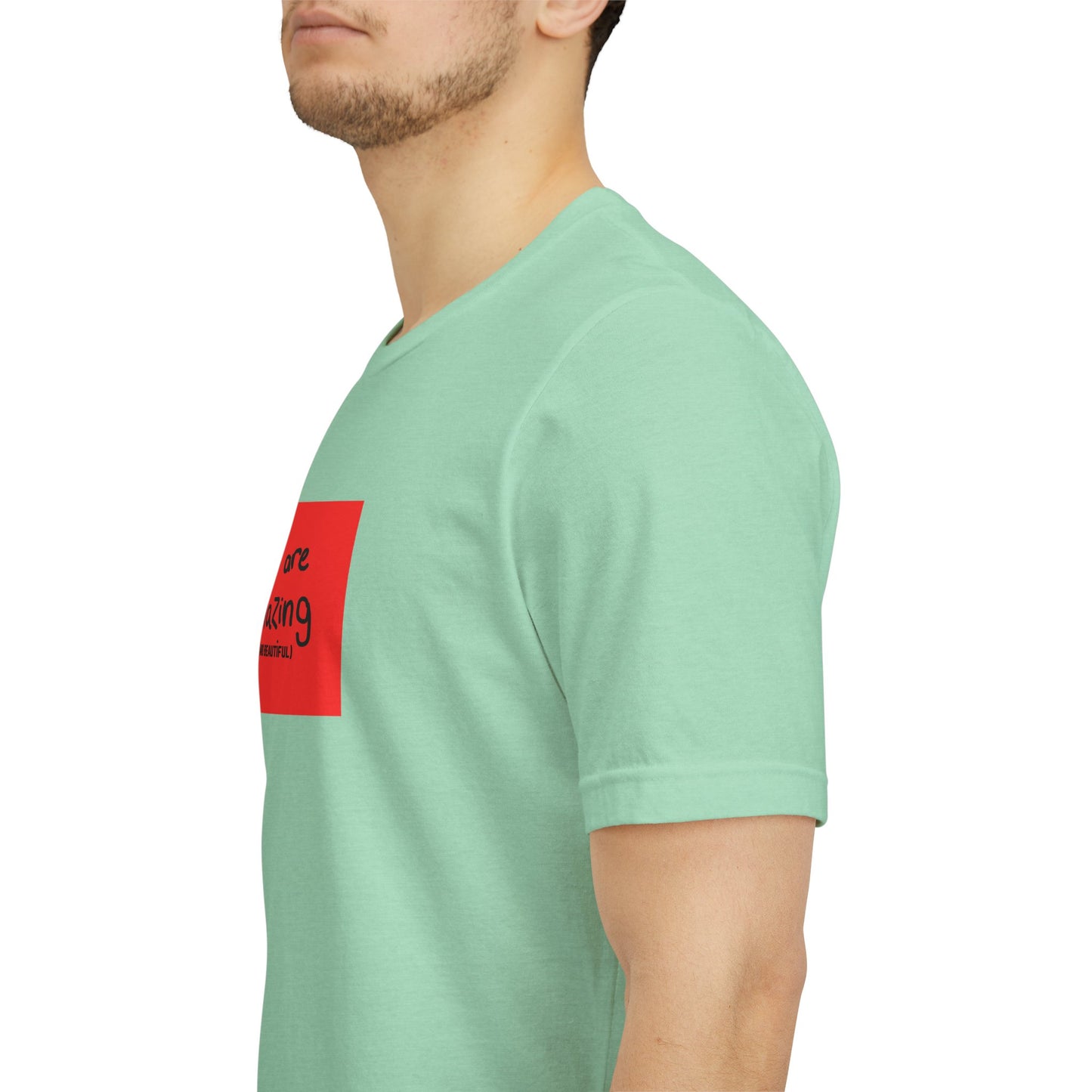 Person wearing a light green t-shirt with a red logo on a white background