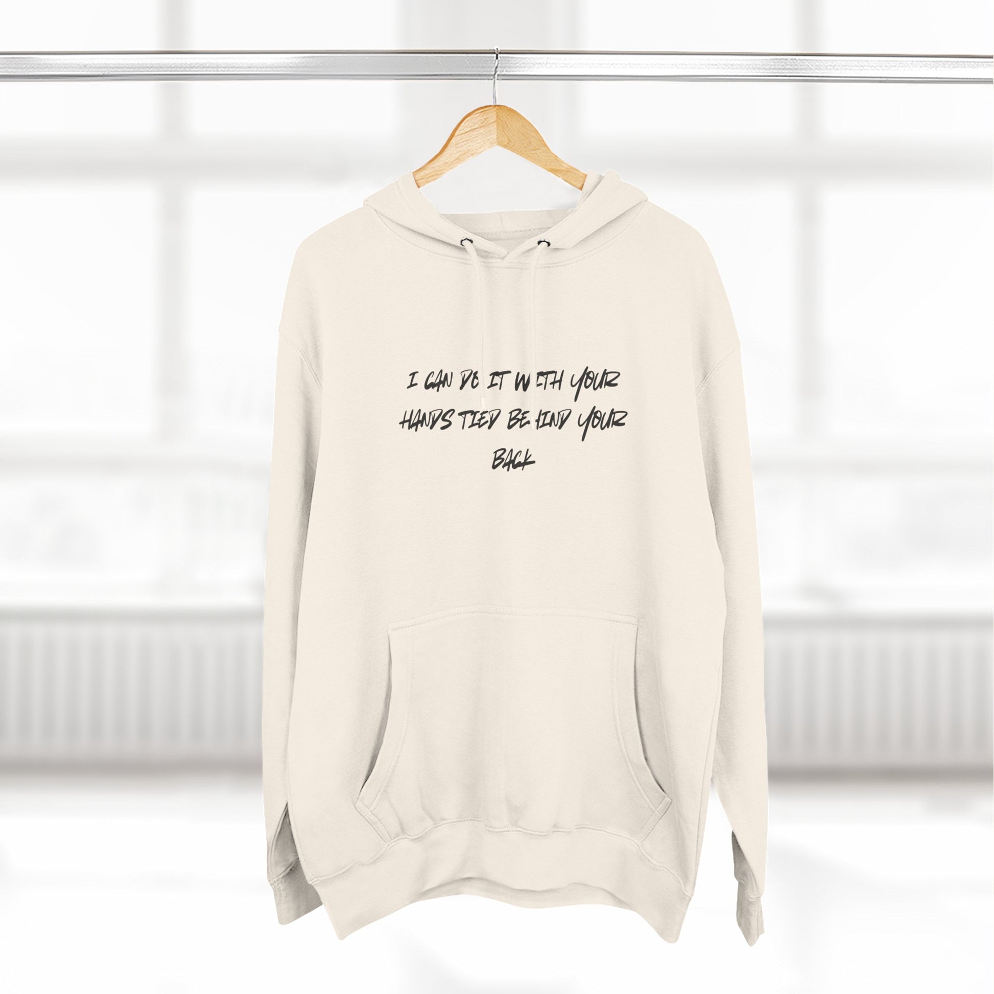 Beige hoodie with text on a hanger against a white background