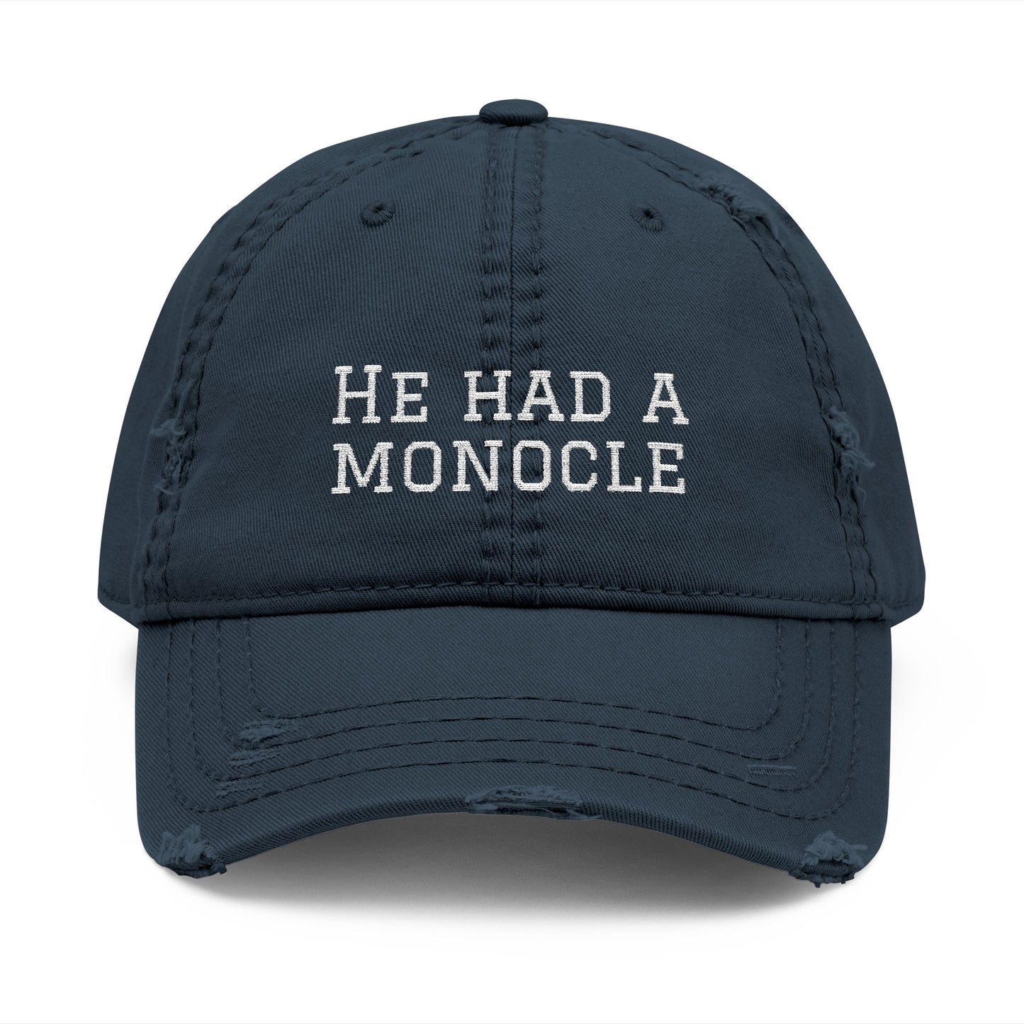 Navy blue cap with 'HE HAD A MONOCLE' text on a white background