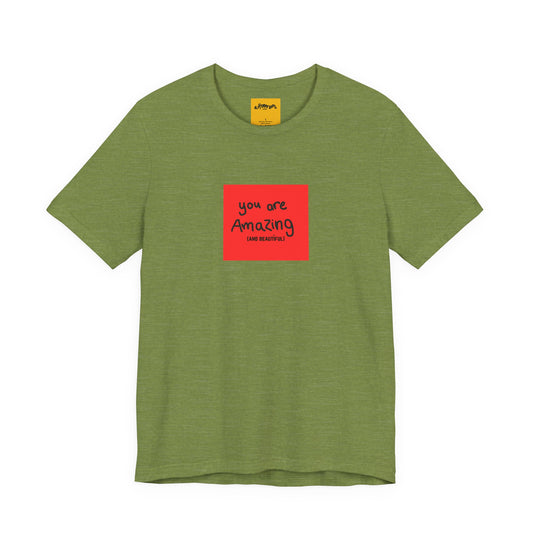 Green t-shirt with a red square and text  reads you are amazing and beautiful on a white background
